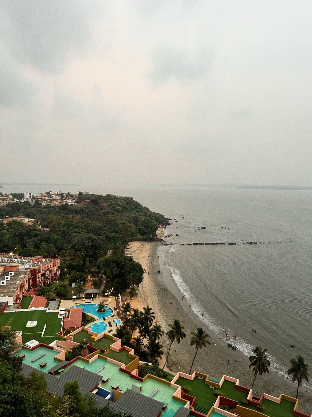 Aerial view of a beachfront resort and pool in Goa